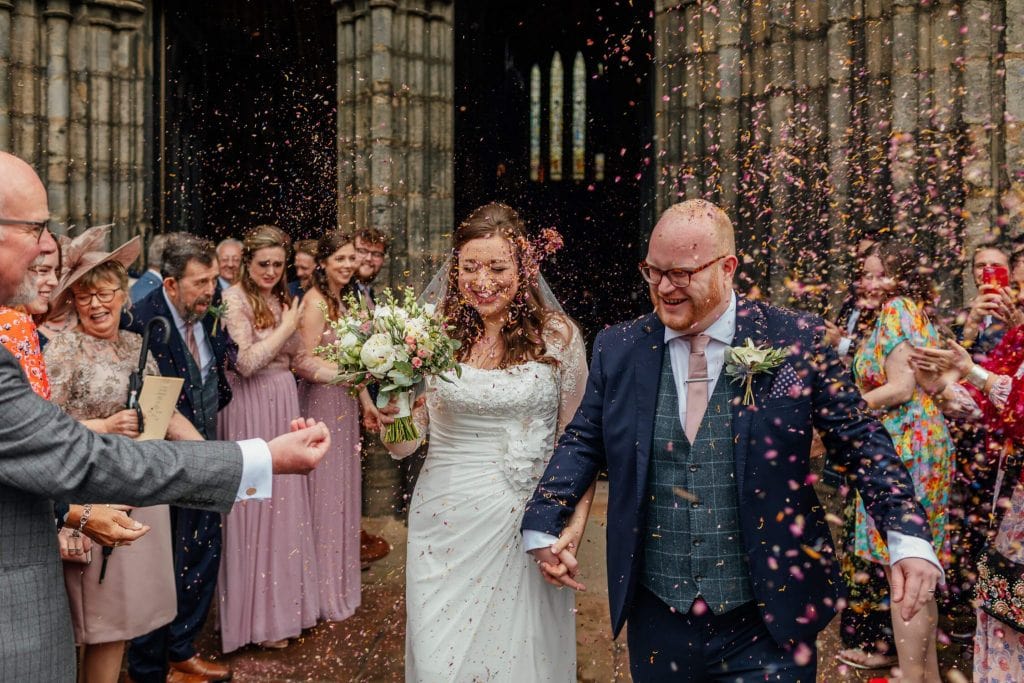 bride groom leaving glasgow cathedral colourful confetti throw in brides face