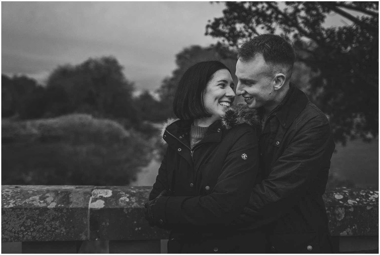 Couple in Pollok Park in Autumnstanding on bridge beside pollok house couples shoot engagement shoot