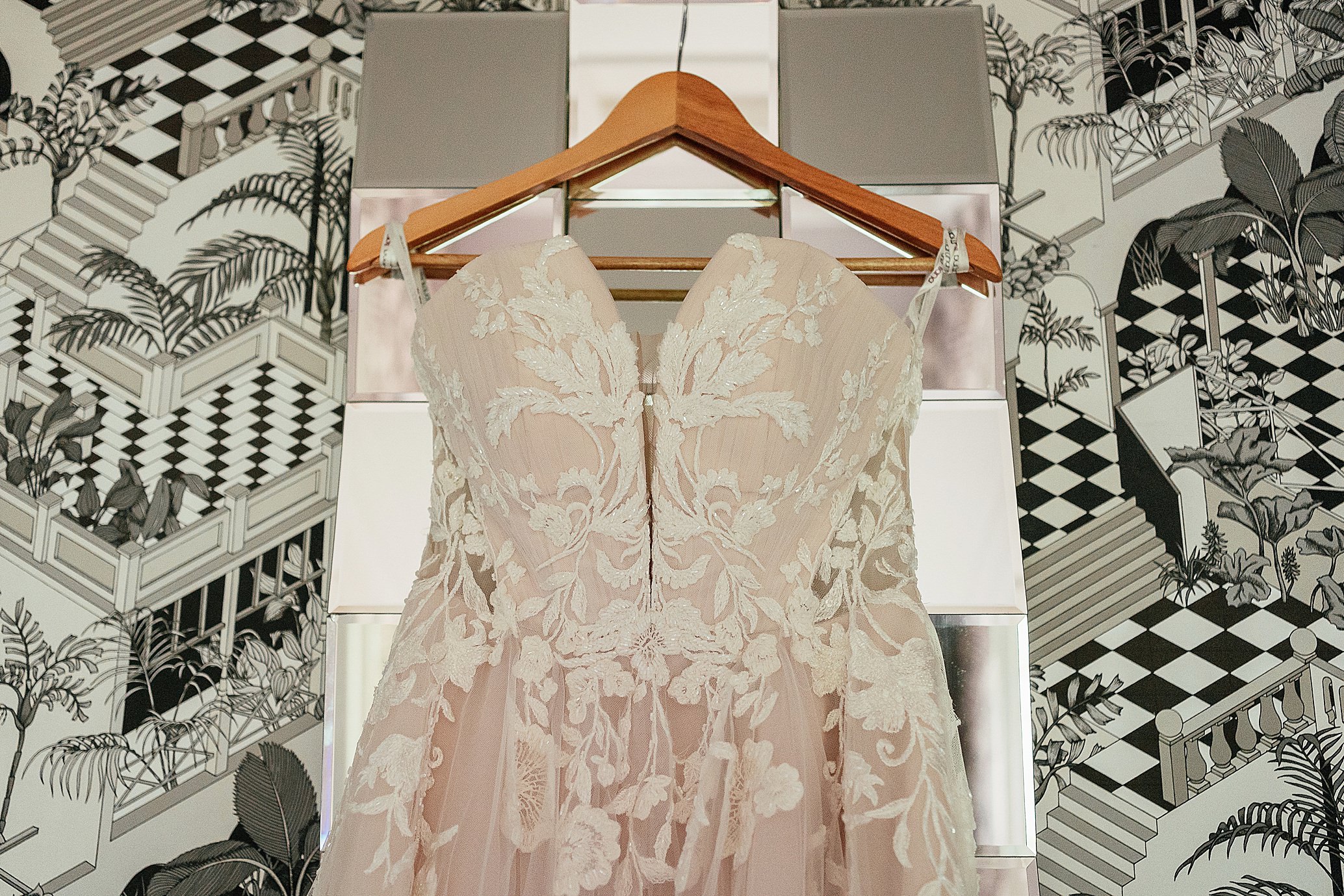 brides lace dress with floral embroidery hanging in room DIY pollokshields burgh hall wedding
