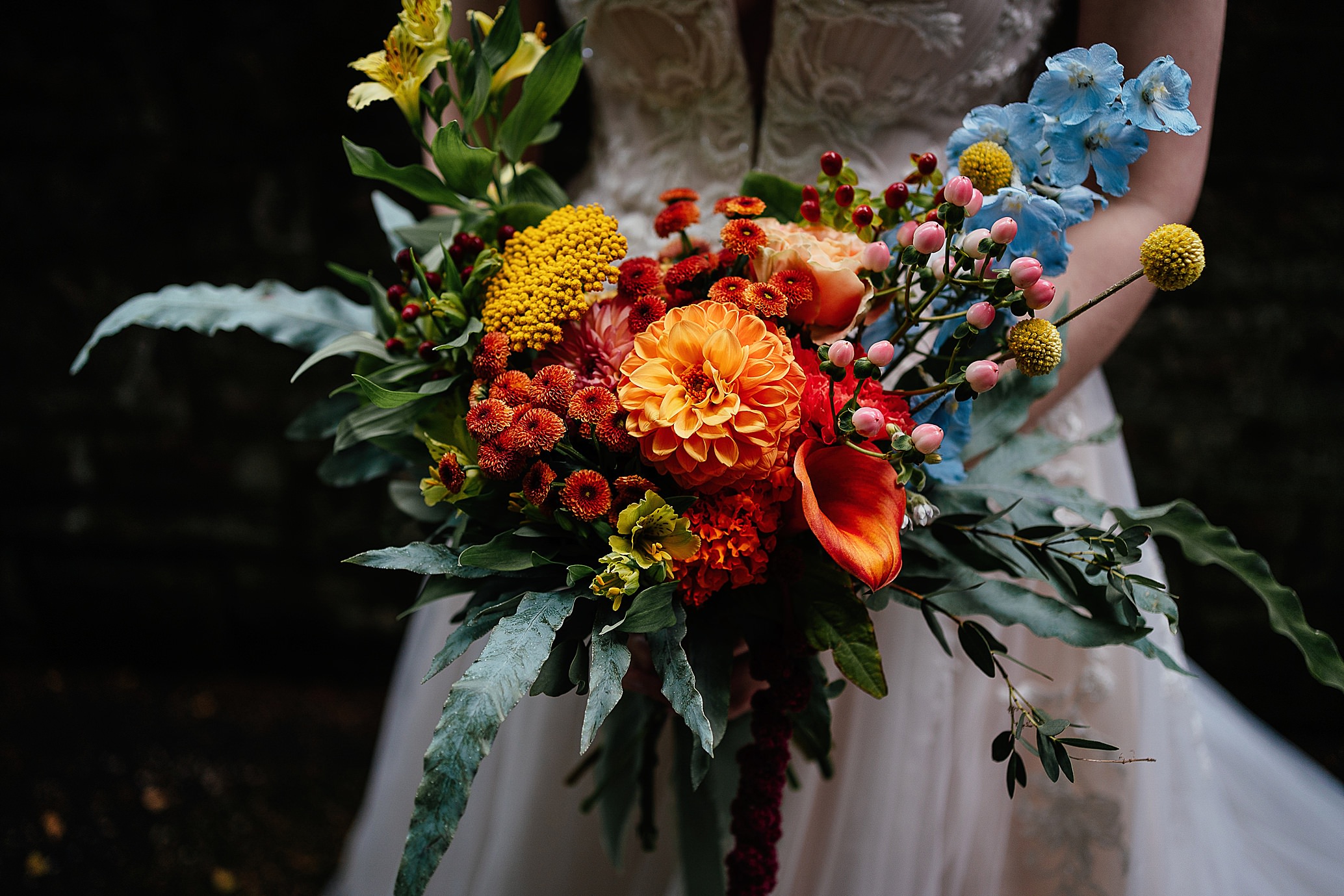 close up of bridal bouquet with oranges yellows reds and blues natural pollokshields burgh hall wedding