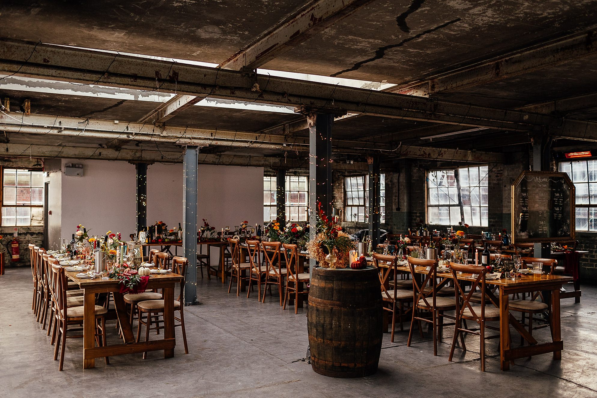 interior of the biscuit factory edinburgh set up for a wedding reception with green, red and yellow autumn touches