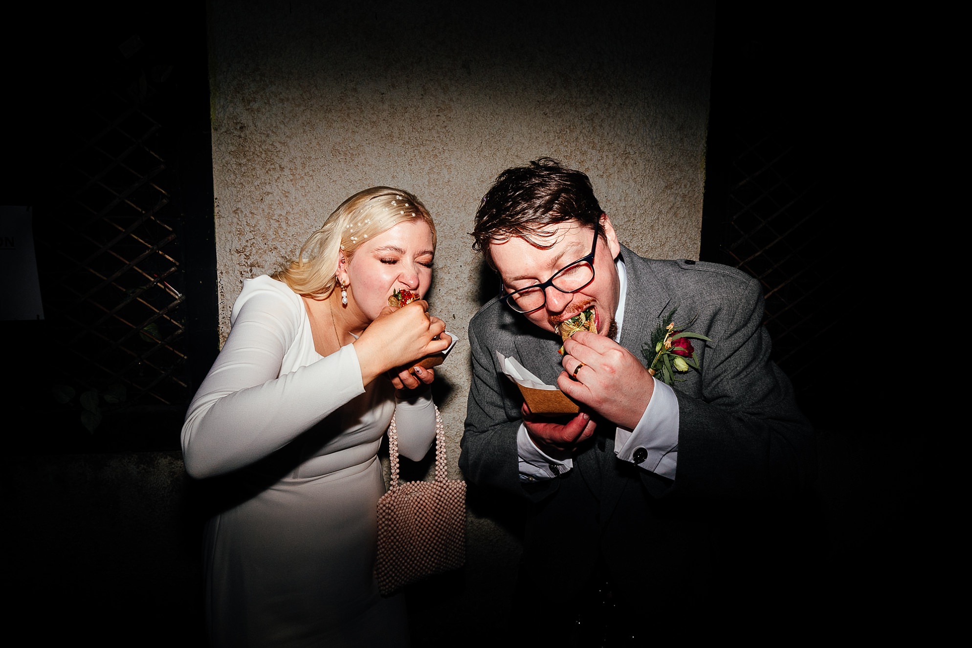 bride and groom eat burritos from a taco food truck at their wedding reception evening party at the biscuit factory downstairs