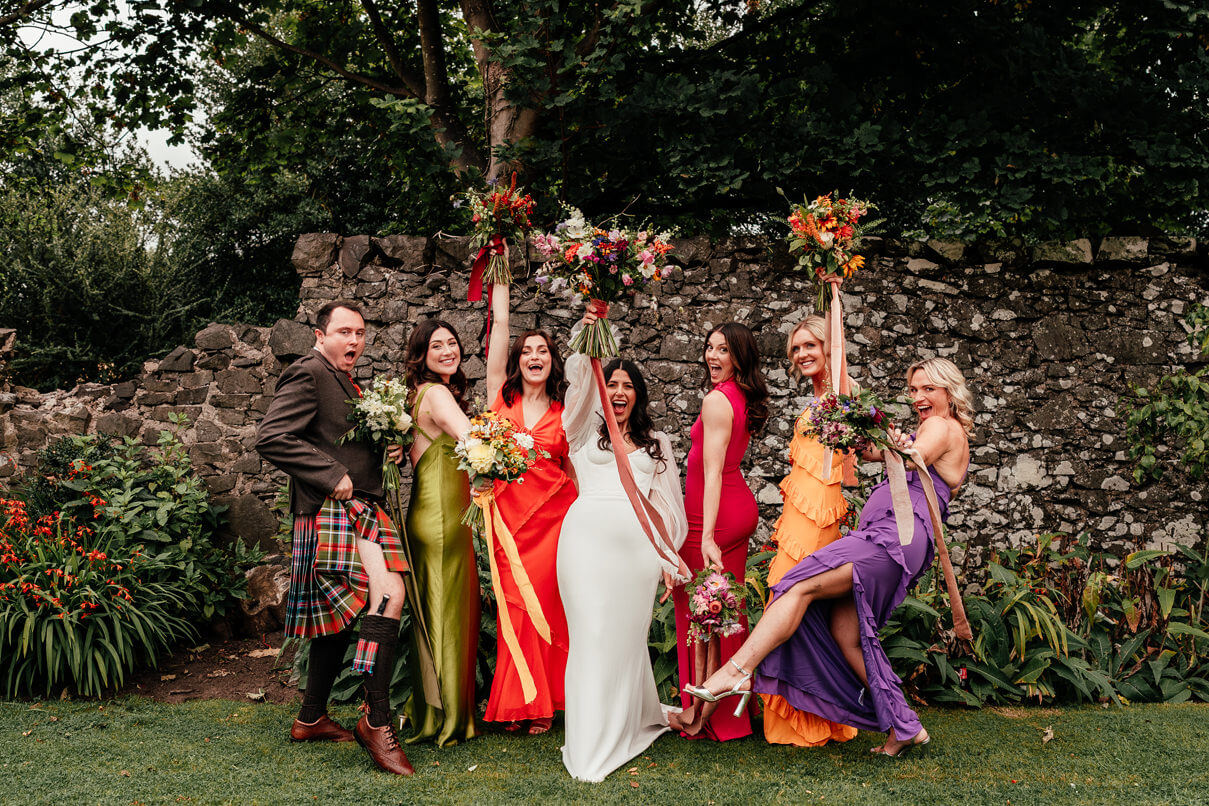 colourfully dressed bridesmaids have fun and laugh at a wedding in scotland